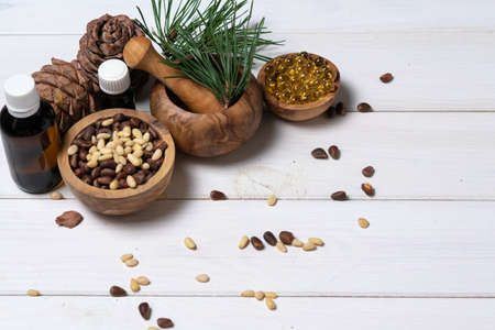 Cedar oil, branches and cedar cone on white. Copy space. Beauty and healthy concept. Energizing facial seed serums.の写真素材