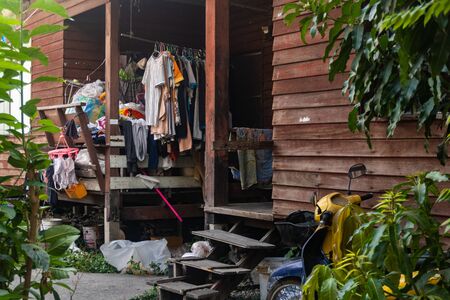 A small courtyard of a local house in Thailand, the clothes hung up to dry and an old motorcycle.の写真素材