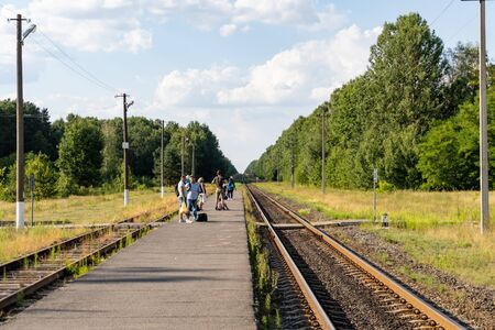 People are waiting for the train to arrive at a small provincial station.