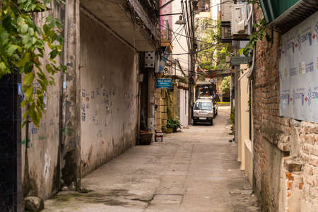 Narrow Hanoi lane with no people, lonely car and dirty wallsの写真素材