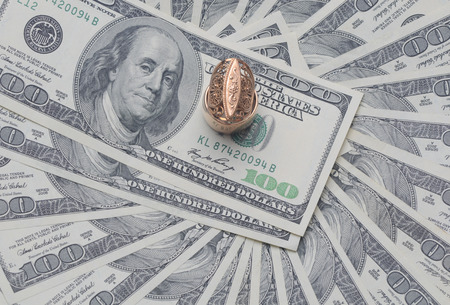 gold signet on a pile of U.S. dollarsの写真素材
