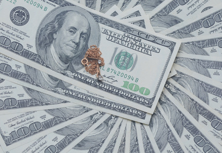 pile of dollars with gold ornaments with stonesの写真素材