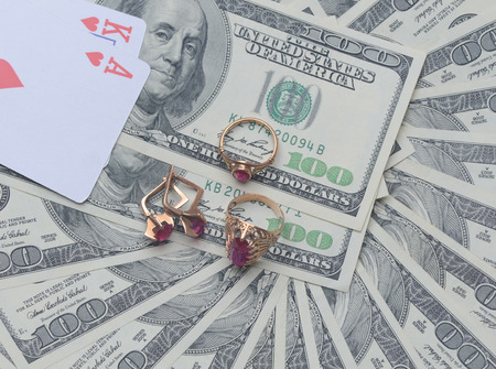 pile of dollars with gold ornaments with stonesの写真素材