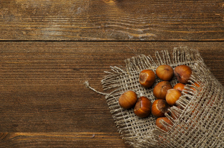 pile of hazelnuts in shell on wooden table .の写真素材