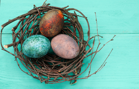 Easter eggs in the nest on wooden background.Rustic style.Top view. Free space for text.の写真素材