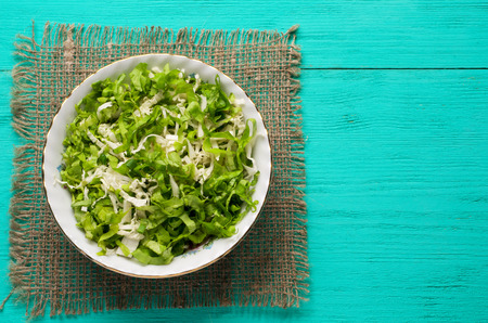 cabbage salad in a plate on a wooden table. Top view. Free space for text.の写真素材