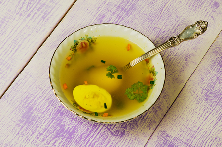 clear soup with vegetables in plate on wooden table .Rustic style.の写真素材