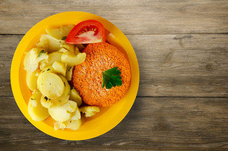 meatball  with potatoes on a wooden background. meatball with a slice of tomato on a plateの写真素材