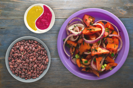 vegetarian food . tomatoes, onion, fennel on a plate on a wooden background. healthy foodの写真素材