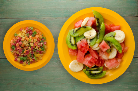 plate of healthy fresh fruit salad on wooden background .の写真素材