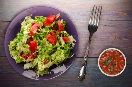 vegetarian food . salad of cabbage tomato on a plate on a wooden background. healthy foodの写真素材