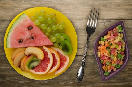 sliced fruit on a wooden background. sliced fruit on a plateの写真素材