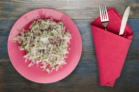 salad daikon, onions and dill on a wooden background. salad on a plateの写真素材