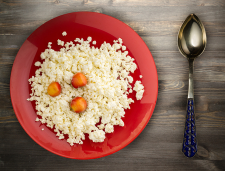 cottage cheese with cherry on a plate on a wooden background. healthy food . tasty breakfast .の写真素材