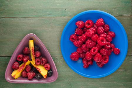 raspberries on a plate. raspberries on wooden background. raspberry top view .