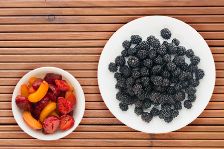 Blackberries on a plate on a wooden background. Vegetarian food. Healthy eating.の写真素材