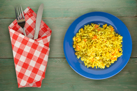 Asian healthy food. Rice (yellow) on a plate with vegetables. Eastern food on a wooden background.の写真素材