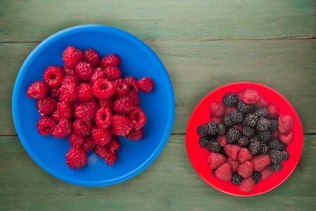 raspberries on a plate. raspberries on wooden background. raspberry top view .