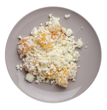 cottage cheese with peaches on a light gray plate isolated on white background.の写真素材