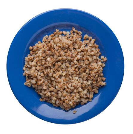 Buckwheat in a blue plate isolated on white background. Buckwheat top view. Healthy food.の写真素材
