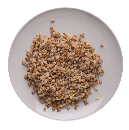 Buckwheat in a light gray plate isolated on white background. Buckwheat top view. Healthy food.の写真素材