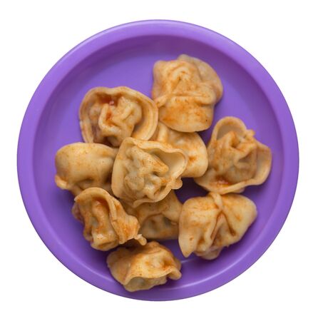 Dumplings on a purple plate isolated on white background. Dumplings in tomato sauce. Dumplings top viewの写真素材
