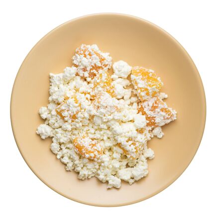 cottage cheese with peaches on a light brown  plate isolated on white background. cottage cheese top view. healthy breakfastの写真素材