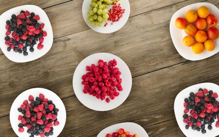 fruits on a plate. vegetarian food on wooden background. vegan food top view .の写真素材