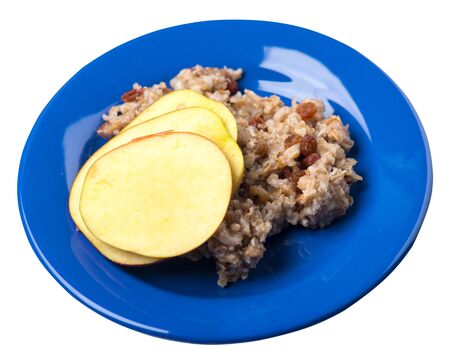 rye flakes with raisins and apples on a blue plate. rage flakes isolated on white background. healthy breakfast top side viewの写真素材