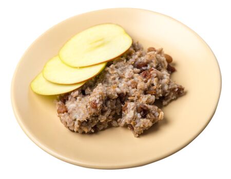 rye flakes with raisins and apples on a ligth brown plate. rage flakes isolated on white background. healthy breakfast top viewの写真素材
