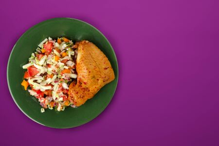 grilled chicken thigh with vegetables on a green  plate on a purple  background.fast food top view.junk foodの写真素材