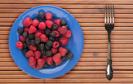 fruits on a blue  plate on a orange  wooden background .fruits on a plate top view.healthy eating....