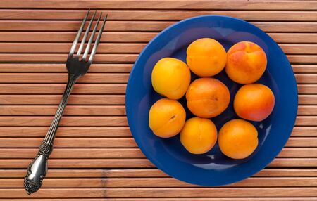 fruits on a blue  plate on a orange  wooden background .fruits on a plate top view.healthy eating. vegetarian foodの写真素材