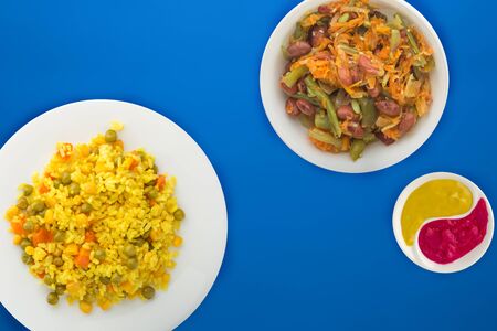  Asian healthy food. yellow rice on a white plate with vegetables. healthy food on a blue background top view.flat layの写真素材