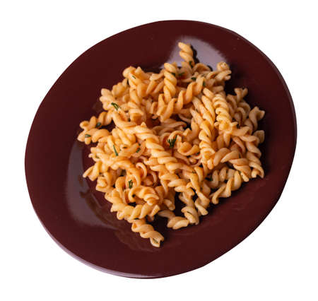 pasta on a dark brown plate isolated on white background. pasta in tomato sauce with dill. pasta top side viewの写真素材