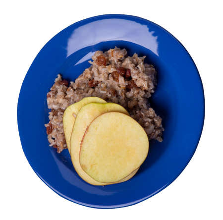 rye flakes with raisins and apples on blue plate. rage flakes isolated on white background. healthy breakfast top side viewの写真素材