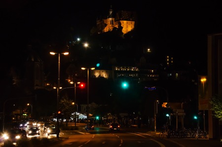 Marburg.Night street with moving cars and brightly lit castle in the background. Night landscape.の写真素材