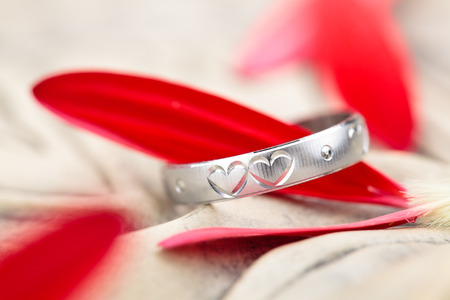 Silver ring with engraved hearts and flower petals.の写真素材