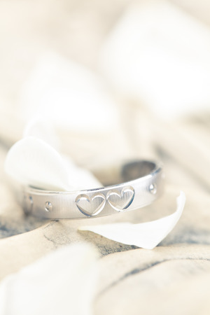 Silver ring with engraved hearts and flower petals.の写真素材