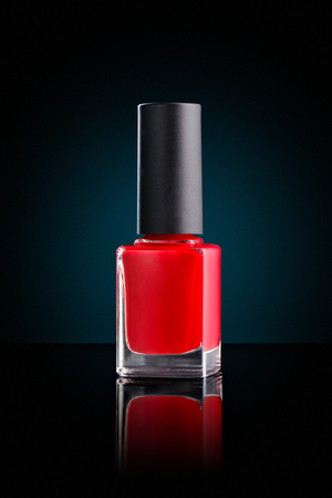 Red nail polish isolated on black background.の写真素材