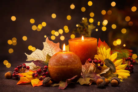 Autumn arrangement of candles, autumn leaves and sunflowers.の写真素材