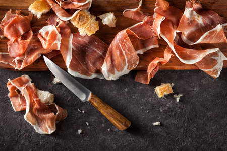 Slices of Prosciutto on dark  background. Top view.の写真素材