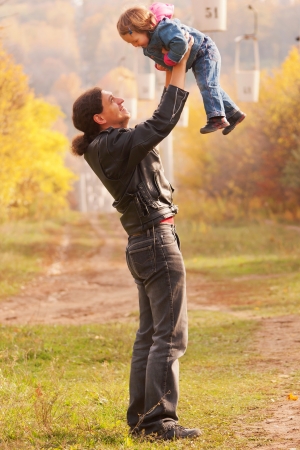 Happy father and baby outdoors. Father raising a child, laughing and playing. Happy family.の写真素材