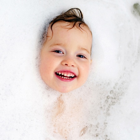 Happy baby in the bath, swimming in the foam  Baby shower の写真素材