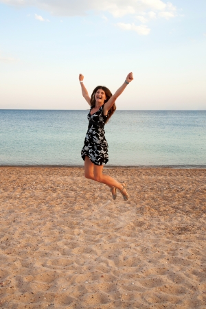 Happy woman jumping on the beachの写真素材