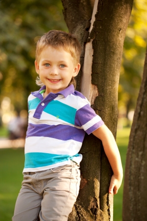Portrait of blue-eyed little boy on the walk near the tree Autumn Park の写真素材