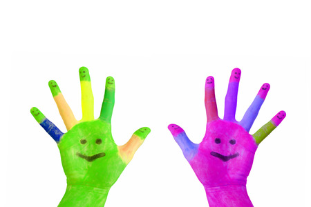 Two painted colorful hands with smiling faces on the palms and fingers raised up  Isolated on white backgroundの写真素材
