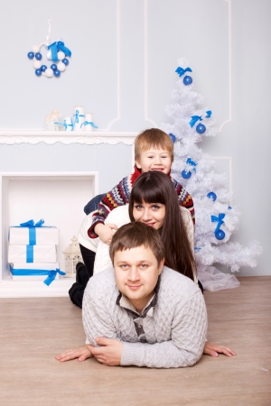 Funny family hugging near the fireplace and Christmas tree. Christmas, New Year, holiday concept.の写真素材