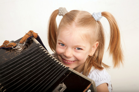 Smiling child with accordion closeup. Little musician.の写真素材