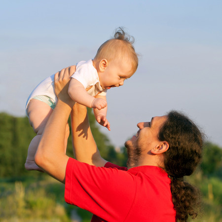 Father and baby playing outdoors. Fathers day, happy family concept.の写真素材